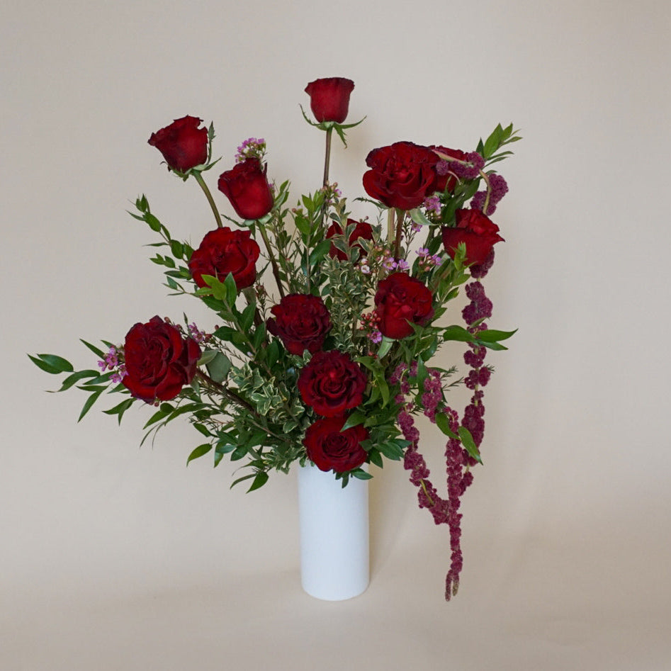 Vase arrangement of red hearts roses in a white vase 