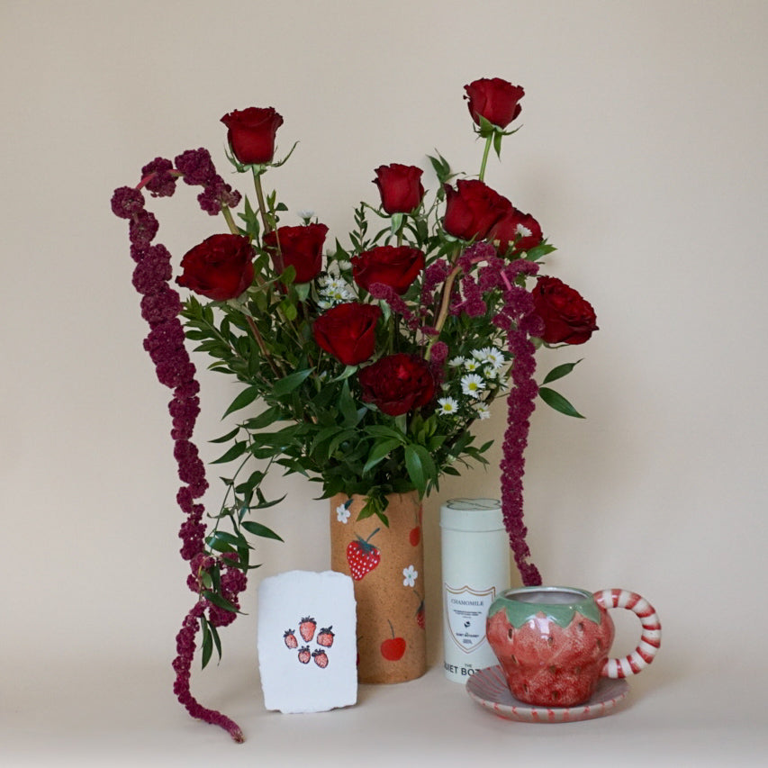 Arrangement of red hearts roses in a cherry & strawberry themed vase with coordinating berry card and strawberry mug 
