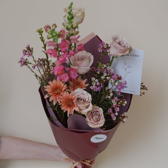 Bouquet of flowers with a card on a light background