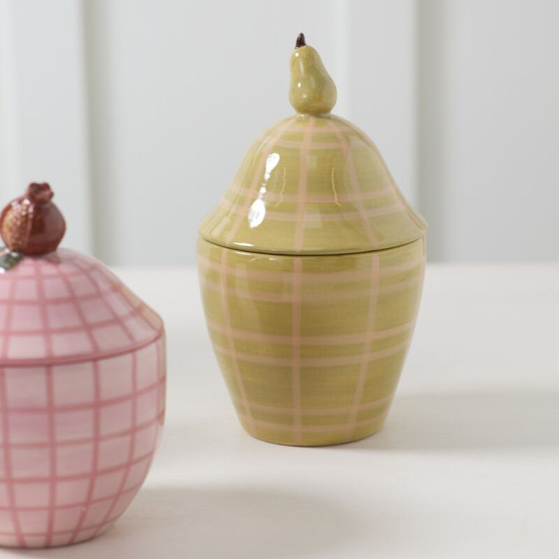Two ceramic jars with plaid patterns and unique fruit handles on a white background
