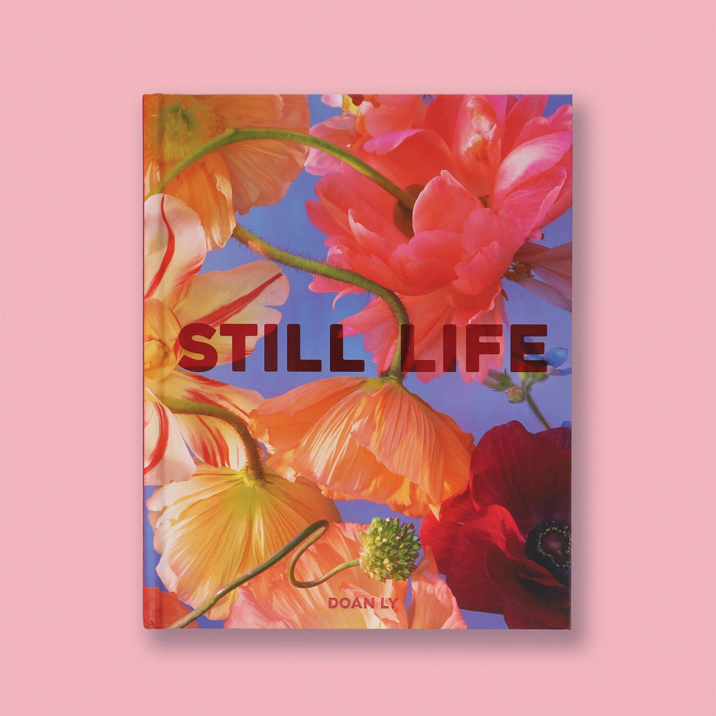 Book cover with colorful flowers and 'STILL LIFE' text on a pink background